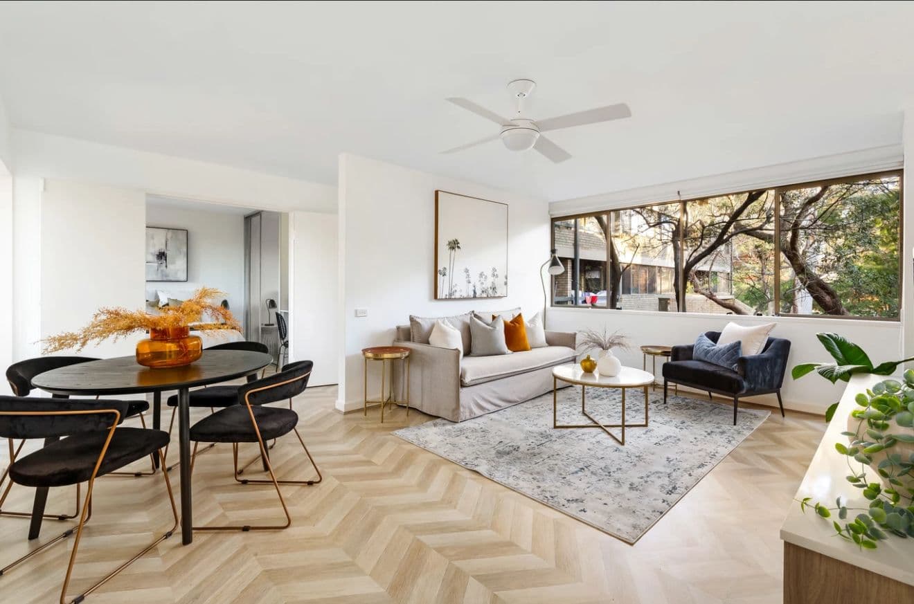 Open-plan living and dining space with chevron timber floors by Reno Build in Sydney