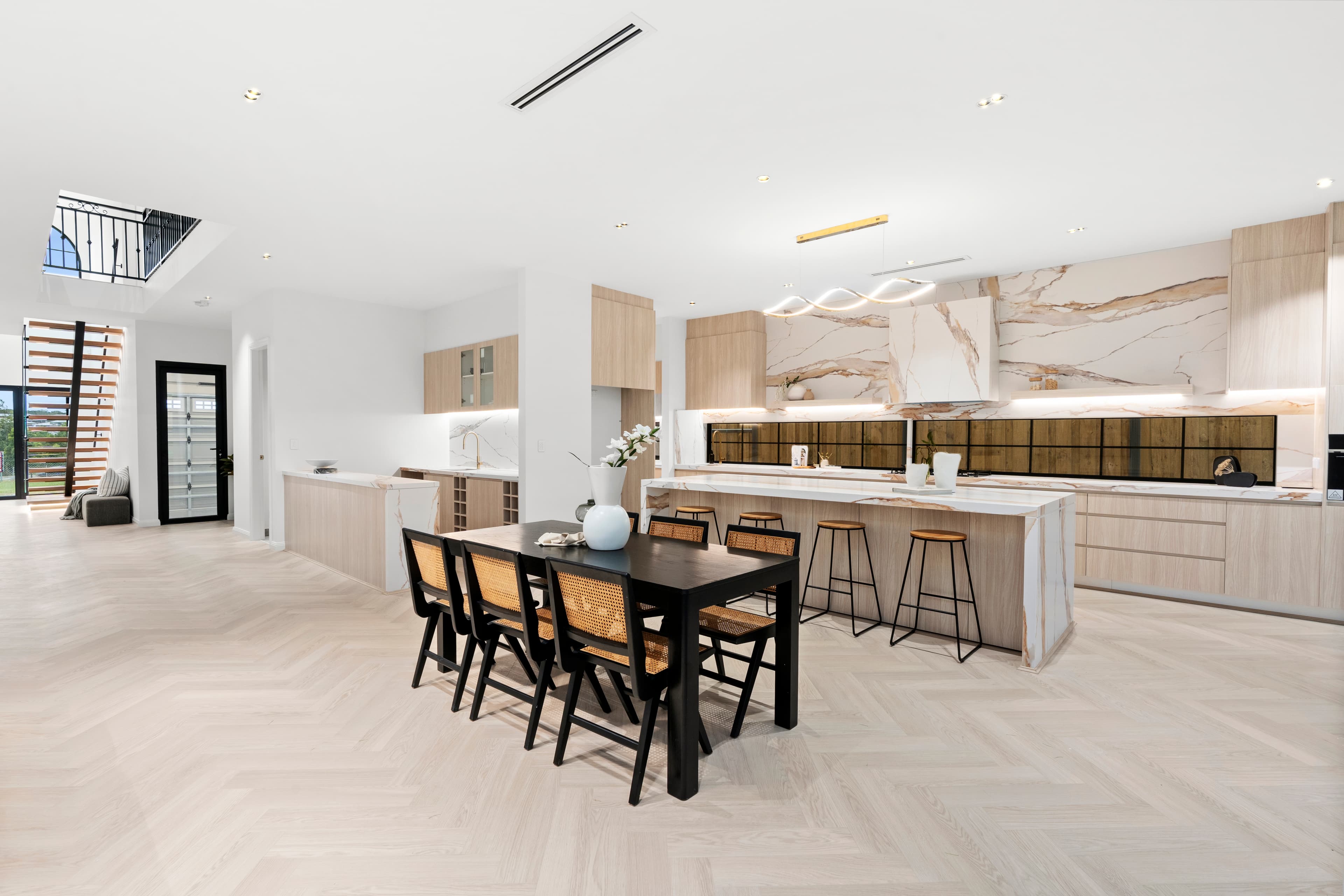 Open-plan kitchen and dining renovation with a marble island by Reno Build on Sydney's Northern Beaches
