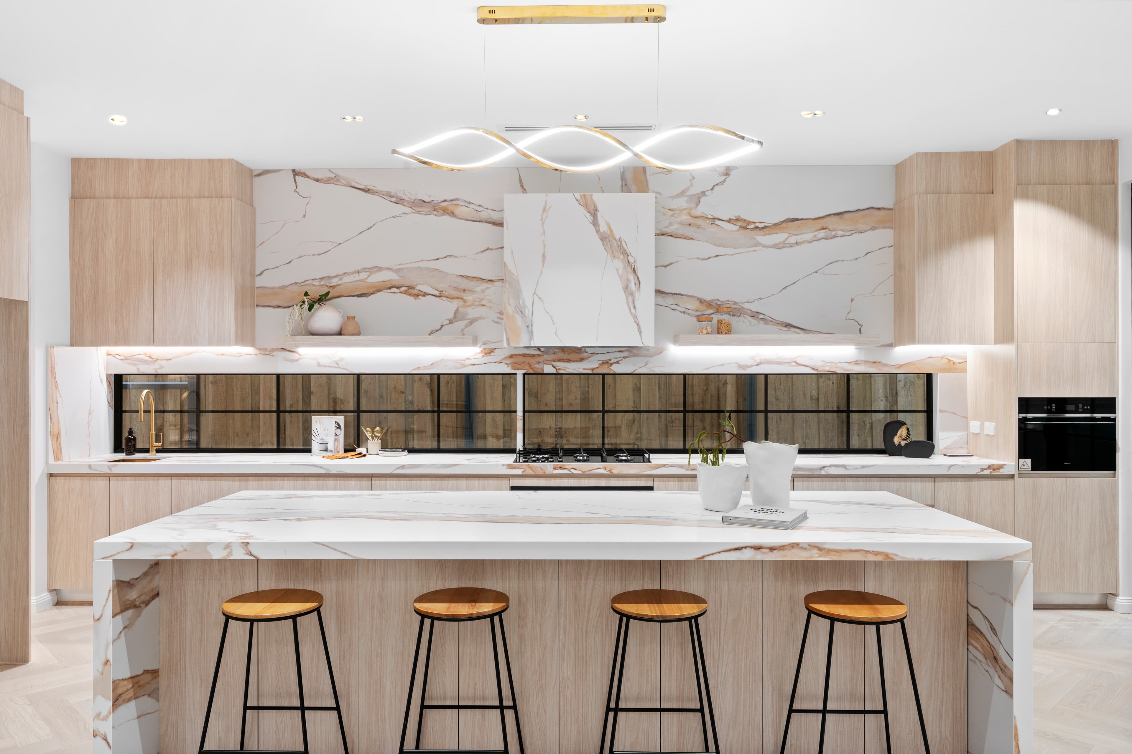 Statement kitchen with a marble range hood and island bench by Reno Build on Sydney's Northern Beaches