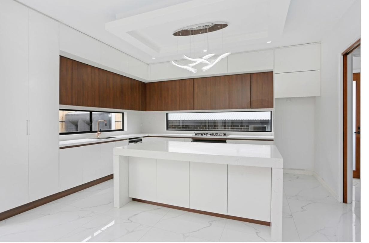 White and timber kitchen renovation with a marble floor by Reno Build on Sydney's Northern Beaches